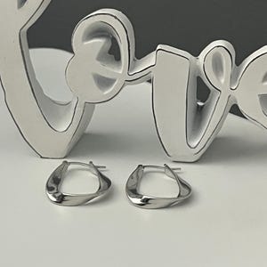 Elegantes pendientes de aro con diseño retorcido Mobius en plata de ley: estilo minimalista y casual.