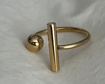 Geometrische roestvrijstalen ring: goudstaaf en bol-ontwerp