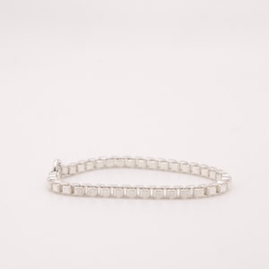 May include: A silver chain bracelet with a box chain design.