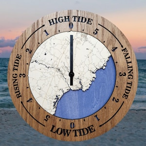 May include: A round wooden tide clock with a map design. The clock face features a light-colored map section over a blue background, with the words "High Tide," "Falling Tide," "Low Tide," and "Rising Tide" around the perimeter.