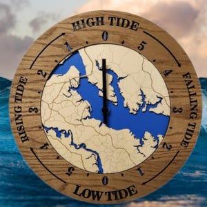 May include: A round wooden tide clock with a blue and beige map design. The clock face features the words "High Tide," "Falling Tide," "Low Tide," and "Rising Tide." The clock hands point to the current tide level.