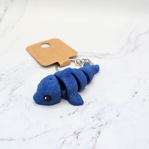 May include: Blue sparkle dolphin keychain with a brown tag.