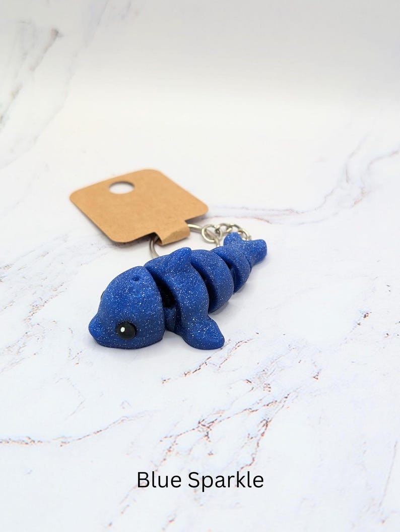 May include: Blue sparkle dolphin keychain with a brown tag.