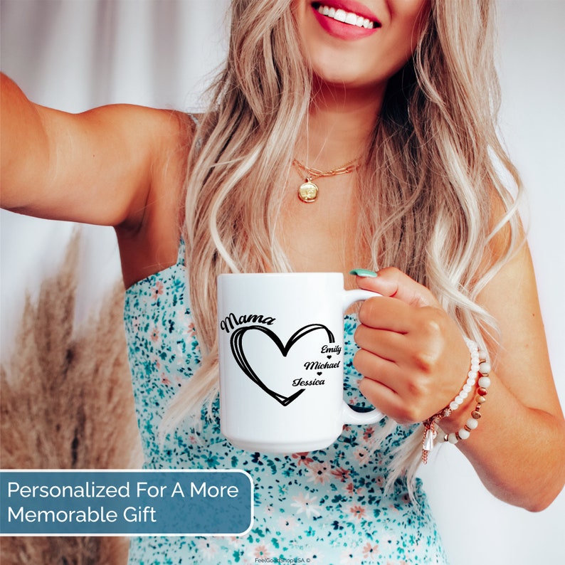 Pu&ograve; includere: Tazza in ceramica bianca con un design a forma di cuore nero e la parola "Mama" sopra. All'interno del cuore sono scritti i nomi "Emily", "Michael" e "Jessica" in nero.