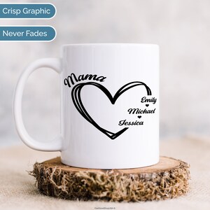 Pu&ograve; includere: Tazza in ceramica bianca con un design nero a forma di cuore con la parola "Mama" sopra e i nomi "Emily", "Michael" e "Jessica" all'interno del cuore.