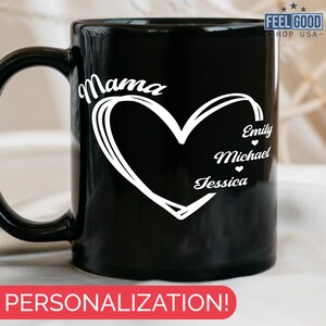 Pu&ograve; includere: Tazza da caff&egrave; in ceramica nera con un design a forma di cuore bianco e la parola "Mama" in alto. All'interno del cuore ci sono i nomi "Emily", "Michael" e "Jessica".
