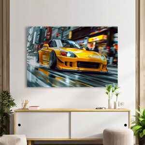 May include: A yellow Honda S2000 sports car driving through a city street. The car has a black front spoiler and black wheels. The car is driving through a wet street with water splashing up from the tires.