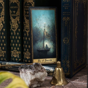 May include: A tarot card with a blue and green background depicting a boat sailing on a body of water. The card is titled "Six of Swords".