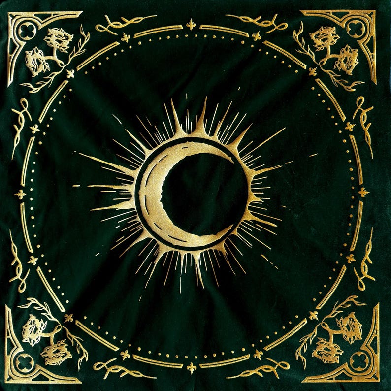 May include: A green velvet square with a gold crescent moon and sunburst design. The design is surrounded by a gold ornate border.
