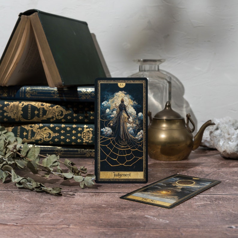 May include: Two tarot cards, one with a gold and black design depicting a figure in a robe and the text "Judgement", and the other with a gold and black design depicting a sun and the text "The Sun".