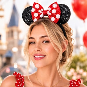 May include: Black sequined mouse ears with a red bow featuring white polka dots. The headband is black. The ears are a popular accessory for theme park visitors.
