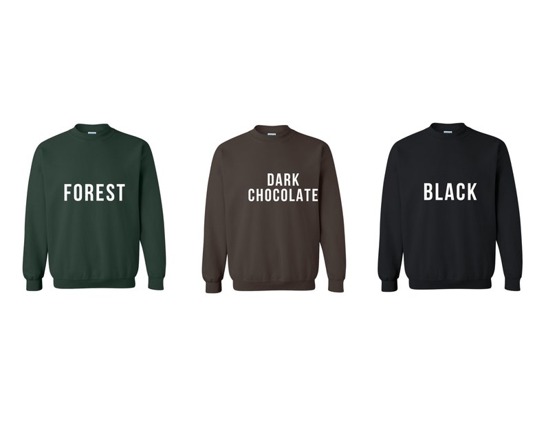 May include: Three crewneck sweatshirts in different colors: forest green, dark chocolate brown, and black. Each sweatshirt has a white text design on the front. The green sweatshirt says "FOREST", the brown sweatshirt says "DARK CHOCOLATE", and the black sweatshirt says "BLACK".