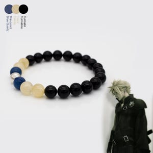 Könnte beinhalten: Ein Armband mit schwarzen, gelben, blauen und silbernen runden Perlen. Das Armband wird auf weißem Hintergrund präsentiert. Das Bild enthält auch eine Farbpalette und eine Figur aus einem Videospiel.