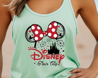 May include: A mint green tank top featuring a Minnie Mouse bow with red polka dots and black mouse ears. The tank top has the text "Disney Girl's Trip 2024" in red and black, with a castle and fireworks graphic.