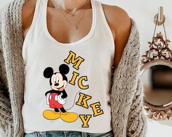 May include: White tank top with a cartoon image of Mickey Mouse and the word "Mickey" spelled vertically in yellow letters.