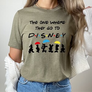May include: A green t-shirt with the text "The One Where They Go To DISNEY" with a row of Mickey Mouse characters holding umbrellas.