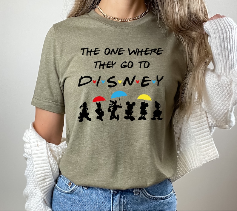 May include: A green t-shirt with the text "The One Where They Go To DISNEY" with a row of Mickey Mouse characters holding umbrellas.