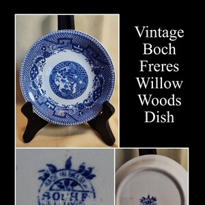 Peut inclure: Une assiette Boch Freres Willow Woods vintage. L'assiette en c&eacute;ramique bleue et blanche pr&eacute;sente un motif de paysage d&eacute;taill&eacute;. L'assiette est pr&eacute;sent&eacute;e sur un support noir. Le texte "Vintage Boch Freres Willow Woods Dish" est visible.