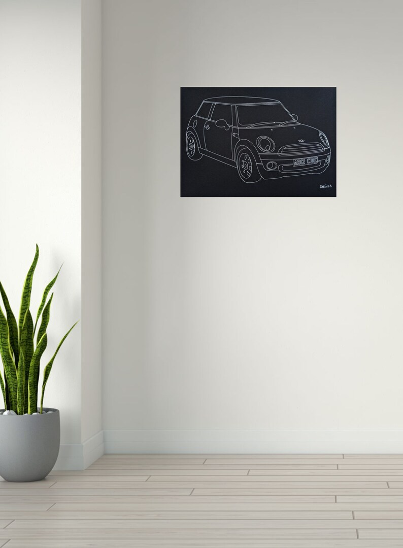 Puede incluir: Dibujo lineal blanco de un Mini Cooper sobre fondo negro. El coche se representa de perfil, mostrando sus caracter&iacute;sticas. La matr&iacute;cula dice "A162 CUB". La obra est&aacute; montada en una pared blanca.