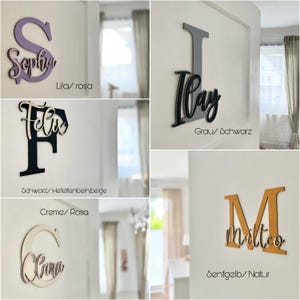 May include: Wooden name signs in various colors and fonts, including purple "Sophia", gray "Ilay", black "Felix", cream "Clara", and mustard yellow "Matteo". Each sign features a letter and a name.