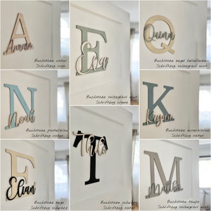 May include: Wooden letter cutouts in various colors and fonts, spelling out names like Aurora, Elian, and Noah. Each letter is mounted on a white door, showcasing a personalized decor theme. The image includes text in German.