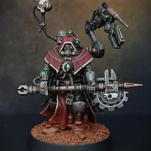 May include: A miniature figure of a robot wearing a red hooded cloak and holding a large metal weapon. The robot has a skull on its chest and is painted in shades of grey, black, and red.