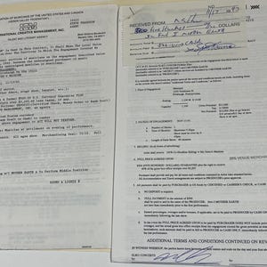 May include: Two open documents with text, possibly contracts or agreements, are displayed. The documents are on a light-coloured surface. One document has a logo and text from the "American Federation of Musicians of the United States and Canada." The other document has handwritten notes.