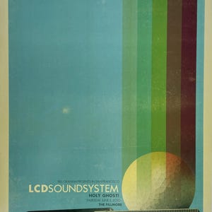 May include: A concert poster for LCD Soundsystem at The Fillmore on June 3, 2010. The design features a large, textured yellow sphere next to a building, with vertical color bands in green and red extending upward against a light blue sky.