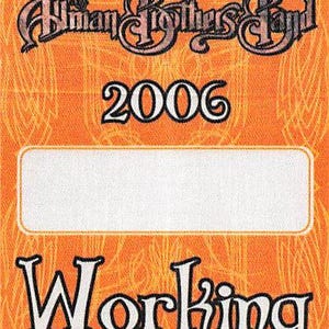 May include: Orange rectangular pass with the text "Allman Brothers Band" in a stylized font above the year "2006". Below a white rectangle is the word "Working" in a bold, decorative font. The background has a subtle, textured pattern.
