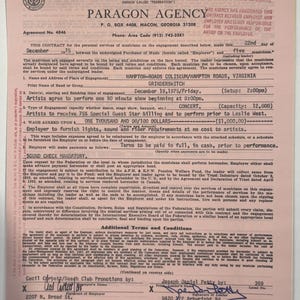 May include: A vintage contract from 1975 between Paragon Agency and Grinderswitch for a concert at Hampton Roads Coliseum. The document includes details like the wage of $1,000, the date, and the names of the involved parties. The contract is on aged paper.