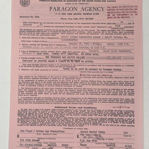 May include: A pink and white Paragon Agency contract from 1975 for a concert by Grinderswitch at Jekyll Island Convention Center. The contract includes details about the engagement, including the date, time, and payment terms.