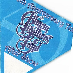 Può includere: Un adesivo triangolare blu con il testo 40th Anniversary Tour, The Allman Brothers Band e After Show in lettere viola scuro. Il design include una forma triangolare bianca nell'angolo inferiore e un motivo geometrico azzurro.