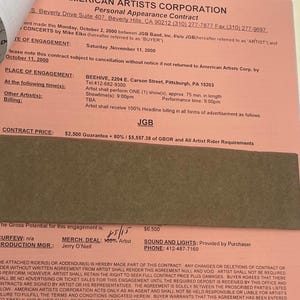 Könnte beinhalten: Ein rosa Vertrag der American Artists Corporation für einen persönlichen Auftritt. Der Vertrag enthält Details wie Datum, Veranstaltungsort und Vertragspreis. Der Text auf dem Vertrag enthält "JGB" und "Beehive, 2204 E. Carson Street, Pittsburgh, PA 15203".