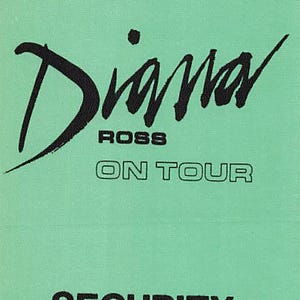 Könnte beinhalten: Ein mintgrüner Sicherheitsausweis mit schwarzem Text. Der Ausweis zeigt den Namen "Diana" in einer stilisierten Schrift, gefolgt von "ROSS" und "ON TOUR". Das Wort "SECURITY" ist unten aufgedruckt.