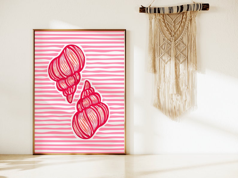 Op de afbeelding: Een ingelijst print met een roze en witte gestreepte achtergrond en twee rode schelpen. De schelpen zijn gestileerd en hebben een gedetailleerd lijntekenontwerp.