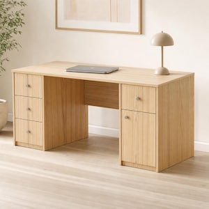May include: A light oak wood desk featuring three stacked drawers on the left side and a single drawer above a cabinet door on the right side. The desk has a flat rectangular top with a closed laptop and a small beige dome-shaped table lamp.