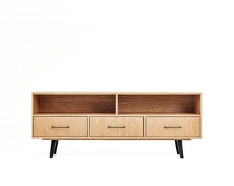 May include: A light wood entertainment center with three drawers and two open shelves. The entertainment center has black metal legs.