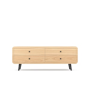 May include: A light wood dresser with four drawers and black metal legs. The dresser has a rounded front edge and black knobs on the drawers.