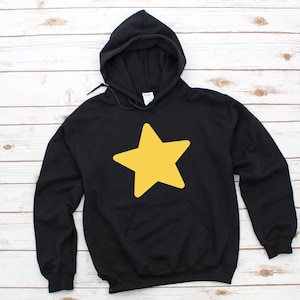 May include: Black hooded sweatshirt with a large yellow star graphic on the front. The sweatshirt has a drawstring hood and a front pocket. The star is a solid, bright yellow color.