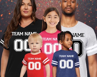 May include: A group of people wearing matching team jerseys. The jerseys are black, red, pink, and blue, with white lettering and numbers. The text "TEAM NAME" is above the number "00".