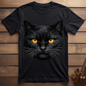 Big Face Black Cat Tshirt Design shown on folded apparel with cat lover accessories