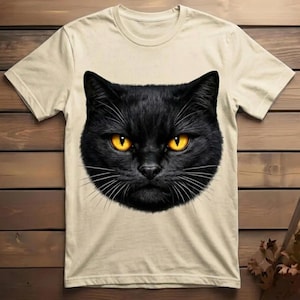 Detailed artwork of a mysterious black cat face with piercing orange eyes, designed as a bold aesthetic print for custom clothing and cat lovers.