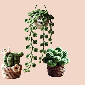May include: Three crocheted potted plants. A green cactus with white flowers in a brown pot, a green succulent in a brown pot, and a hanging green plant with a brown pot.