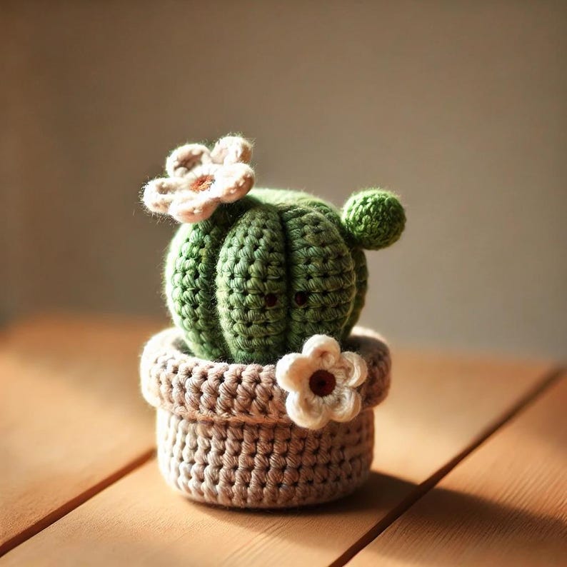 May include: A crocheted cactus plant with white flowers in a brown crocheted pot.