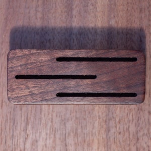 May include: A dark brown wooden knife block with four slots for knives.