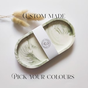 May include: Oval decorative tray with a marbled green and white design. The tray has a white band wrapped around it with a logo. The words "CUSTOM MADE" and "PICK YOUR COLOURS" are printed on the image.