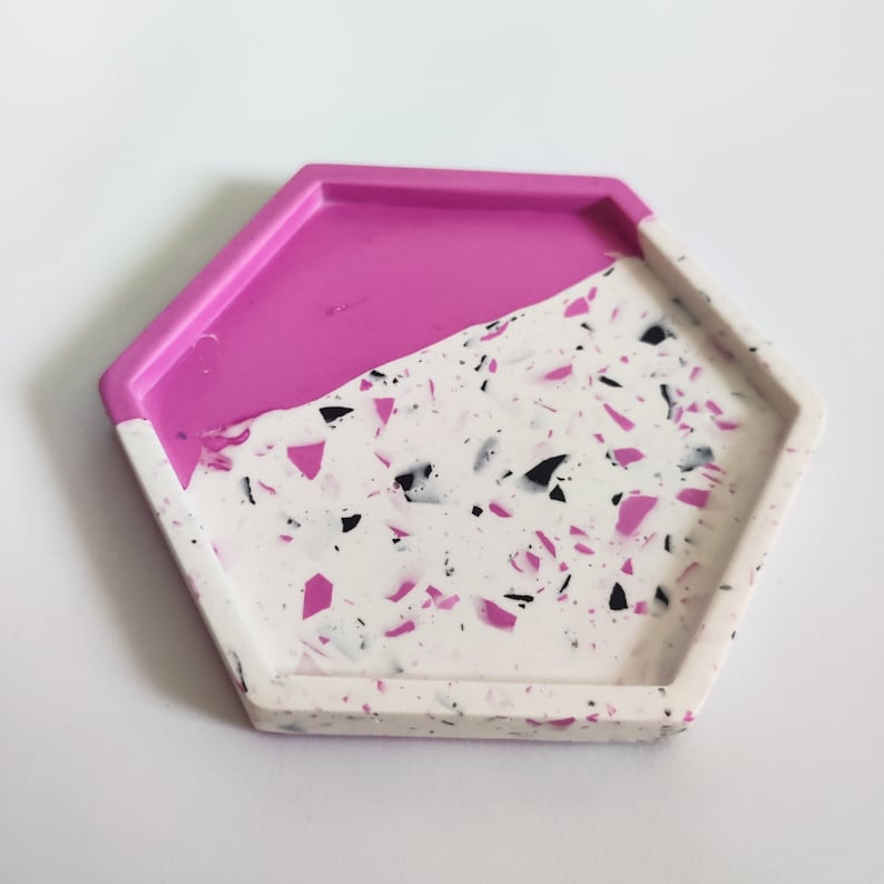 May include: A hexagonal tray with a pink and white speckled design. The top half of the tray is solid pink, while the bottom half is white with black and pink speckles.