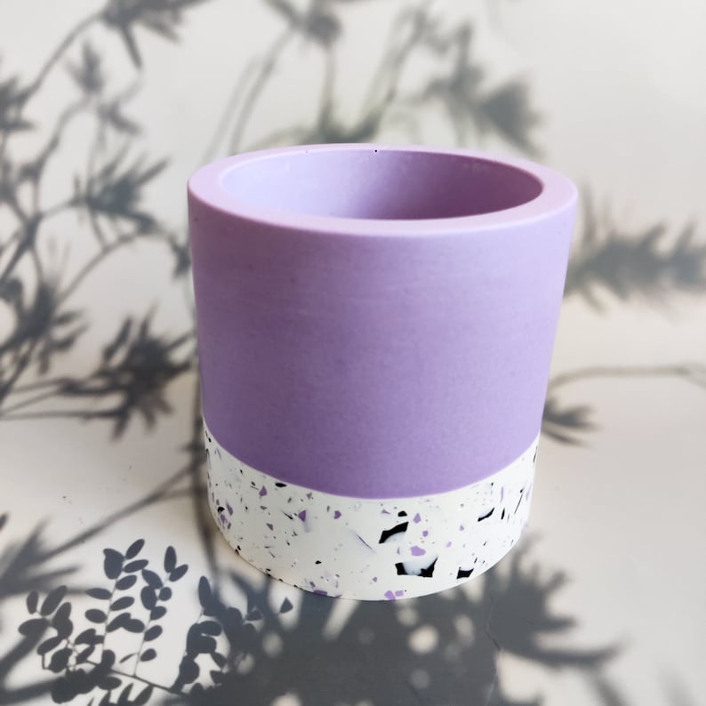 A small, cylindrical planter with a purple top and a white speckled bottom. The planter is made of Jesmonite and has a smooth, matte finish.