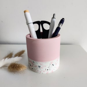Pink and white terrazzo desk organiser with a white marker, scissors, and two pens inside.