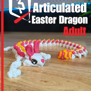 Può includere: Un giocattolo articolato a forma di drago pasquale bianco e rosa con testa di coniglio e uovo. Il testo "Articulated Easter Dragon Adult" è visualizzato in bianco e rosso. Prodotto da Plastic 3D.